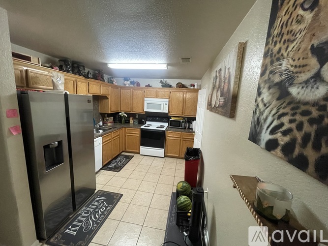 A kitchen with a refrigerator, microwave, and oven.