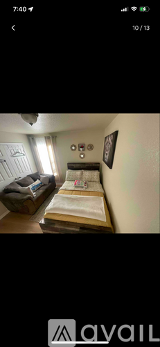 A bedroom with a bed, nightstand, and a picture on the wall.