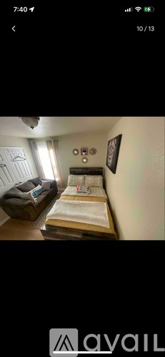 A bedroom with a bed, nightstand, and a picture on the wall.