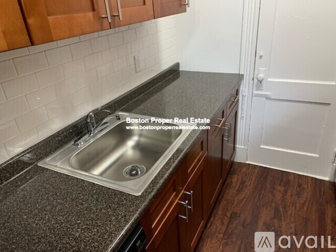 A kitchen with a sink and wooden cabinets.