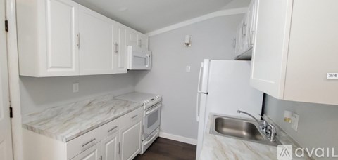 A kitchen with white cabinets and appliances.