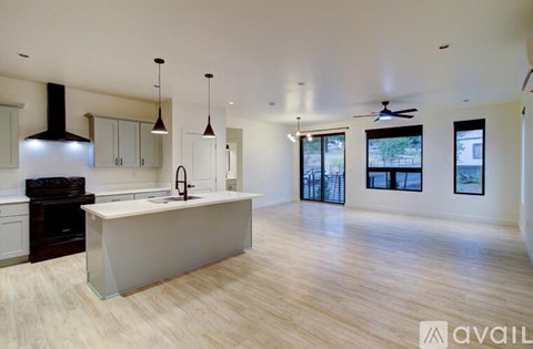 A modern kitchen with a large island and wooden floors.