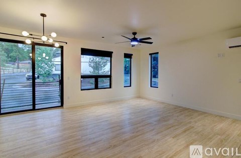 A spacious room with a ceiling fan and sliding glass doors.