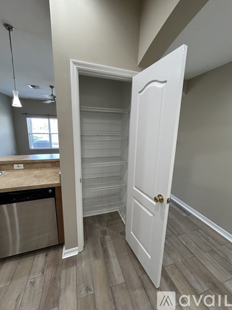 A white door is open to a room with a wooden floor.