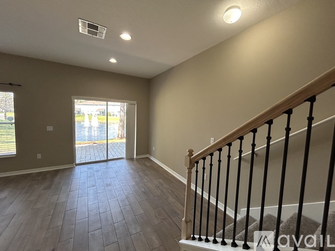 A room with a staircase and a sliding glass door.
