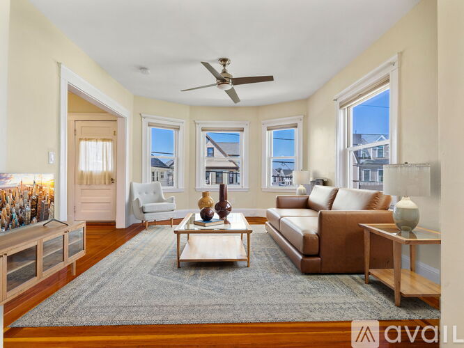 A living room with a brown sofa, a white armchair, and a wooden coffee table.