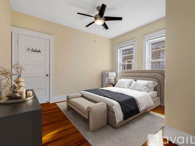 A bedroom with a large bed and a ceiling fan.