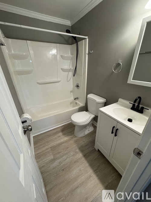 A bathroom with a toilet, sink, and shower.