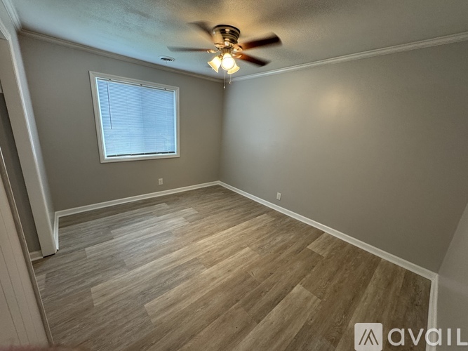 A room with a ceiling fan and a window.