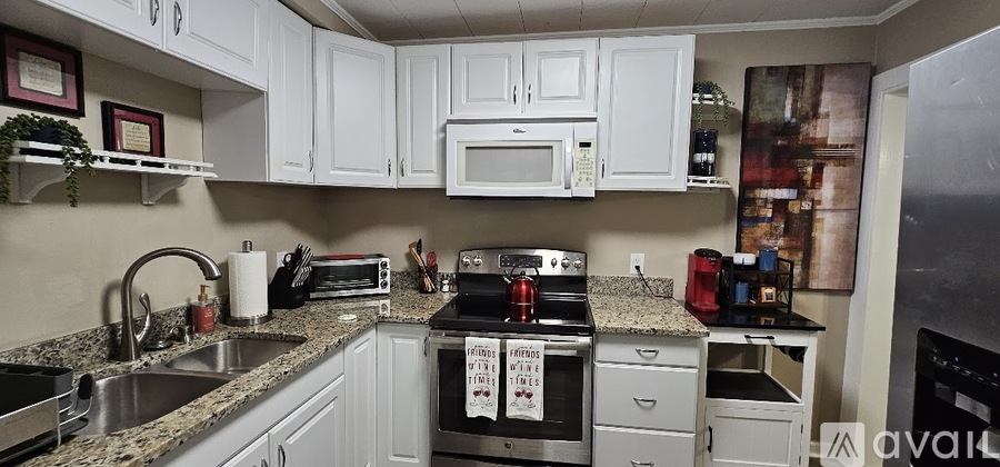 A kitchen with white cabinets and granite countertops.