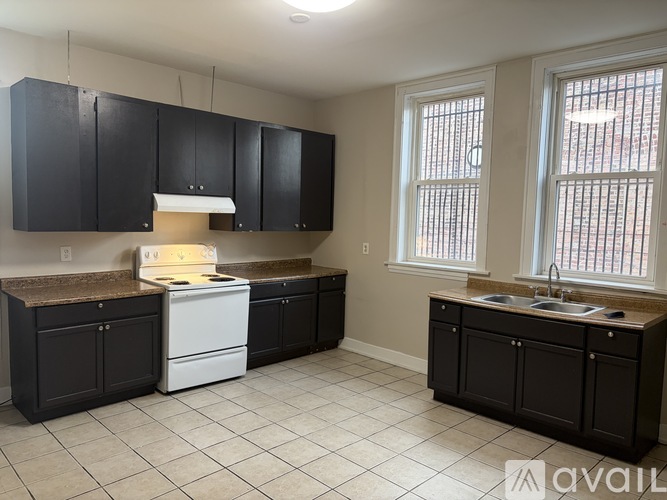 A kitchen with black cabinets and a white dishwasher.