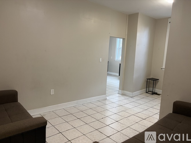A living room with a couch and a tiled floor.