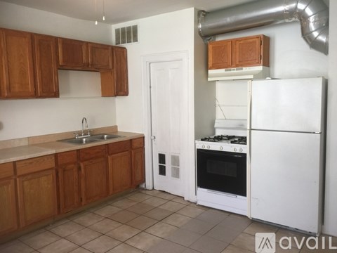 A kitchen with wooden cabinets and a white refrigerator.