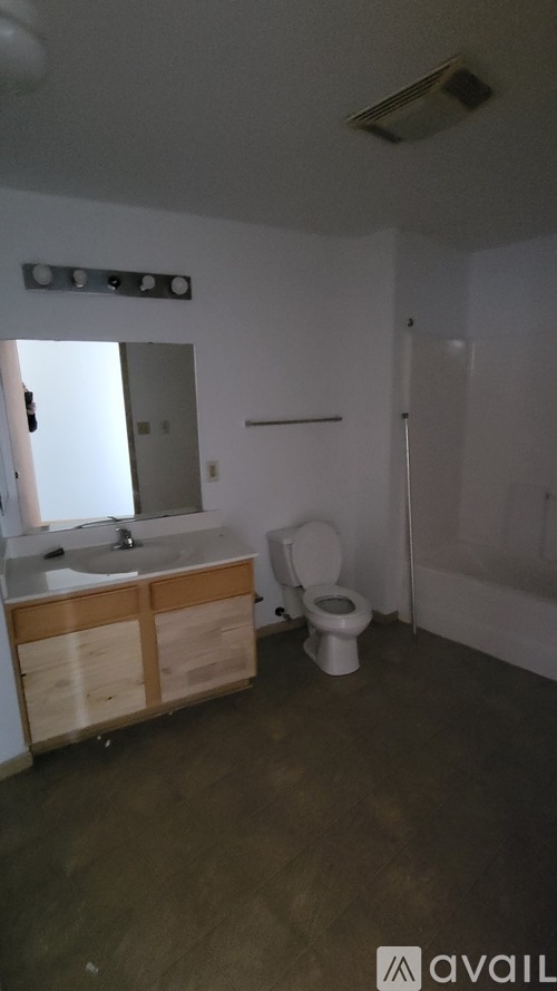 A bathroom with a toilet, sink, and mirror.
