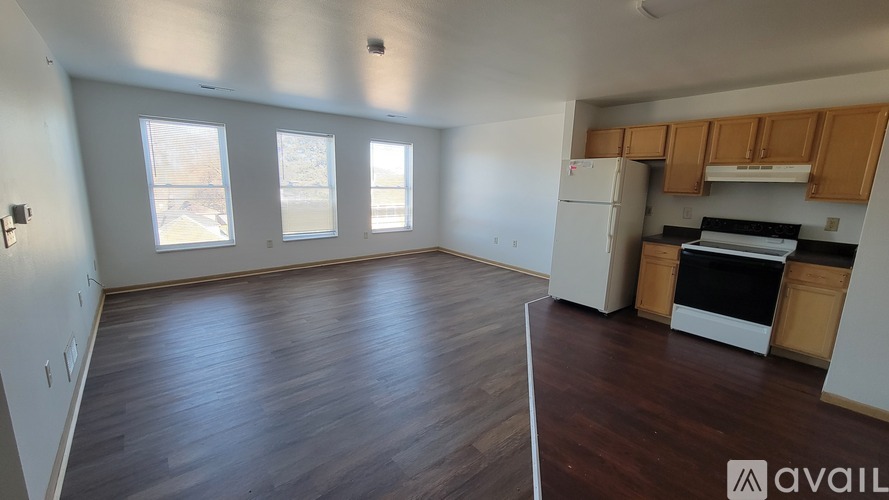 A kitchen area with wooden floors and white appliances.