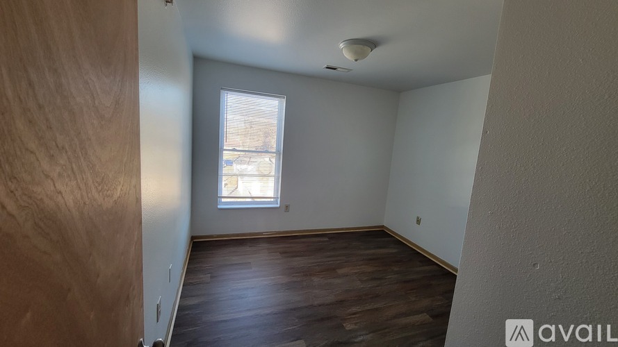 A room with wooden floors and a window letting in natural light.