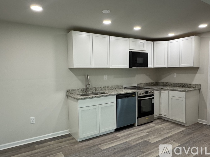 A kitchen with white cabinets and a granite countertop.