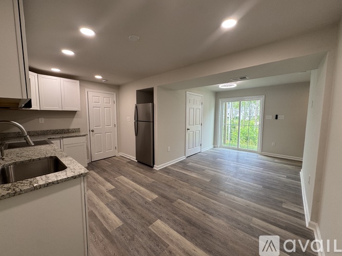 A kitchen with a sink, refrigerator, and cabinets.