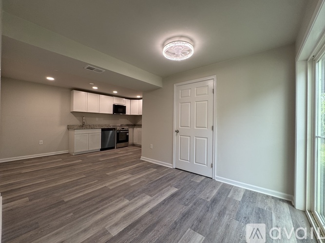 A spacious room with a kitchen area and a door.