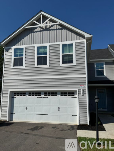 A house with a grey and white exterior and a white garage door.