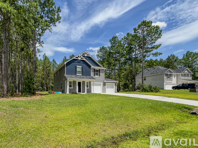 A house with a blue roof is surrounded by trees and grass.
