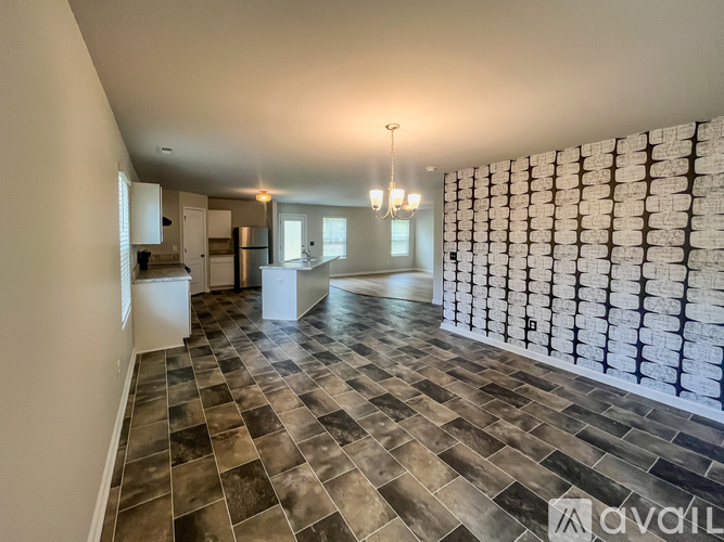 A spacious room with a tiled floor and a wall of framed pictures.