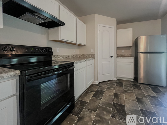 A kitchen with a black oven and a black stove top.