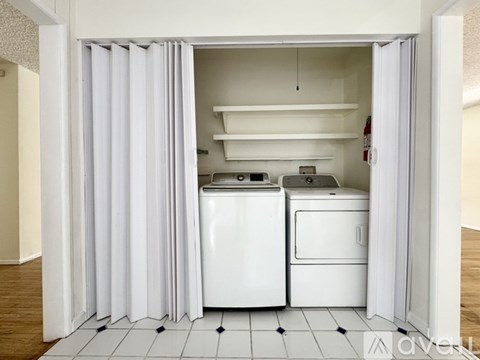A white kitchen with a dishwasher and a washing machine.