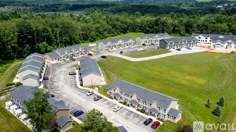 A bird's eye view of a housing complex with multiple houses and cars parked in the driveways.