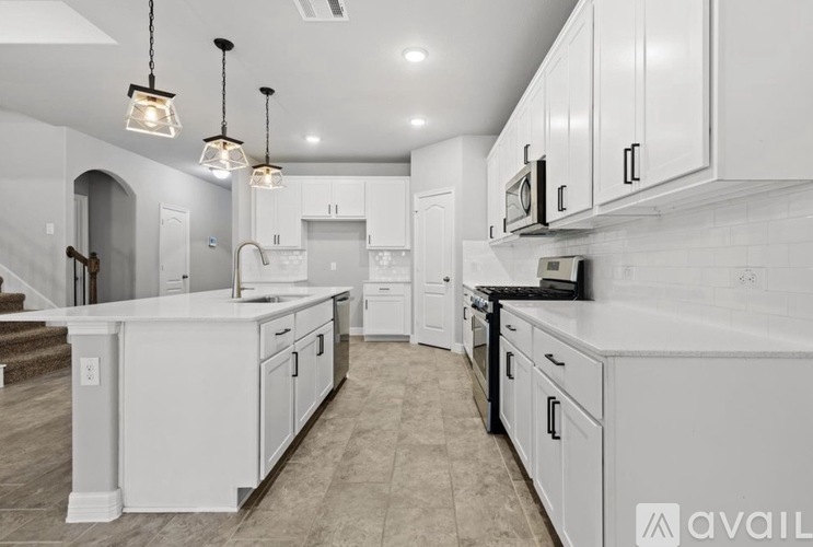 A modern kitchen with white cabinets and a center island.