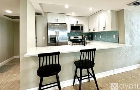 Two black chairs are placed in front of a kitchen island.