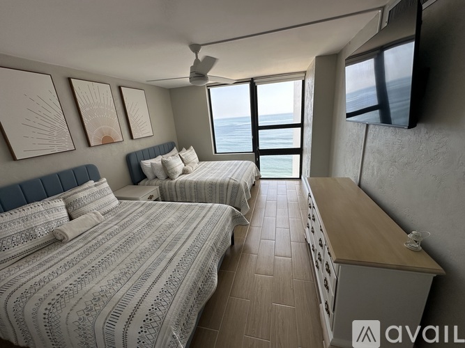 A bedroom with two beds and a television mounted on the wall.