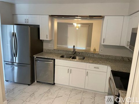 A kitchen with a granite countertop and white cabinets.