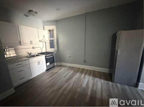 A kitchen with white cabinets and a wooden floor.