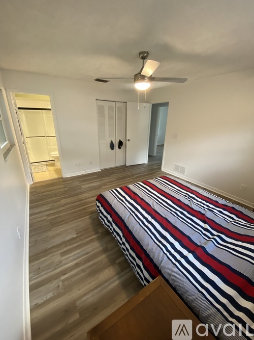 A bedroom with a bed, a ceiling fan, and a closet.