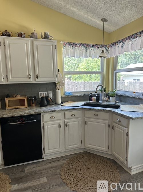 A kitchen with a black oven and white cabinets.