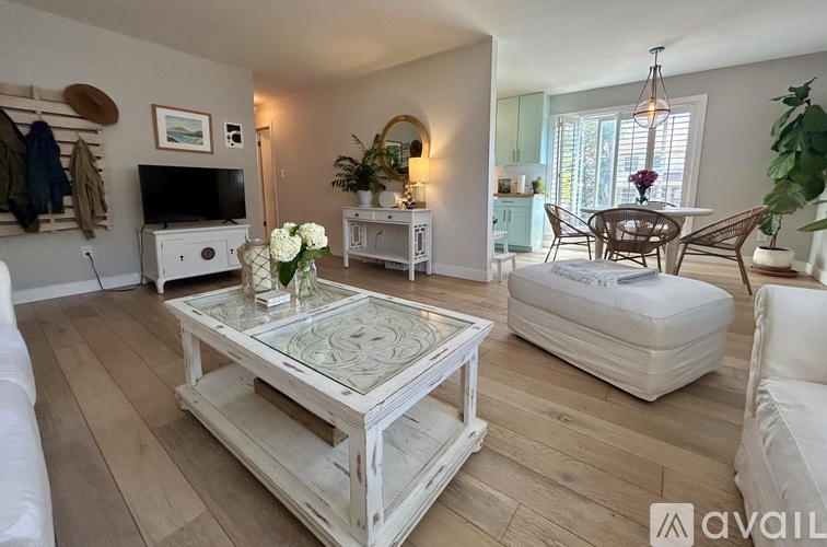 A living room with a glass coffee table and a white sofa.