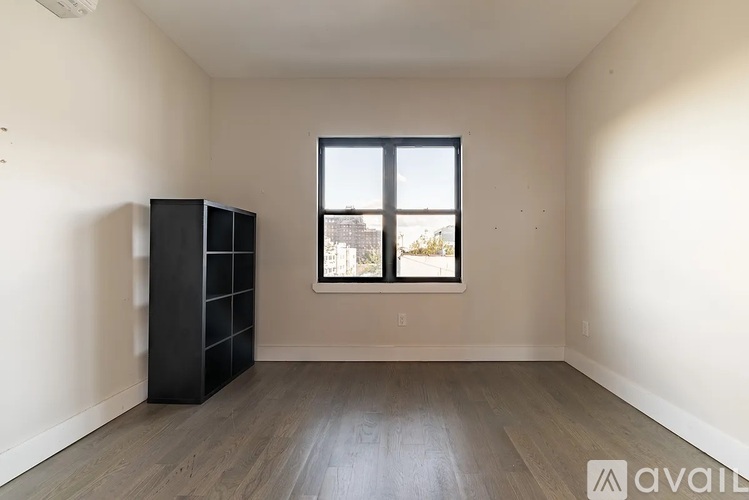 A room with a black cabinet and a window.