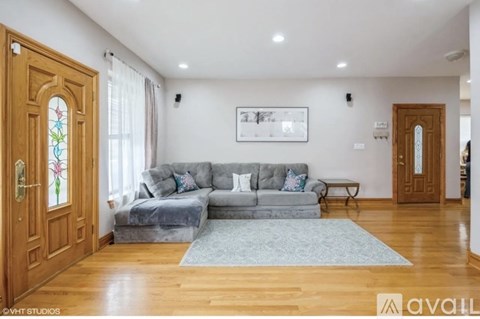 A living room with a grey couch and a wooden door.