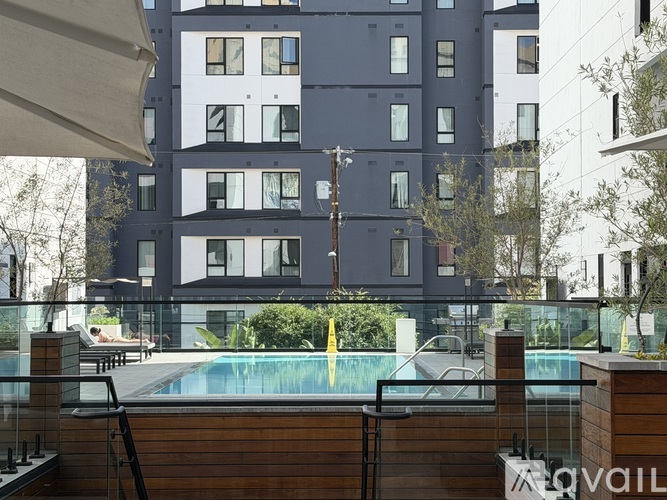 A modern apartment building with a pool in the foreground.