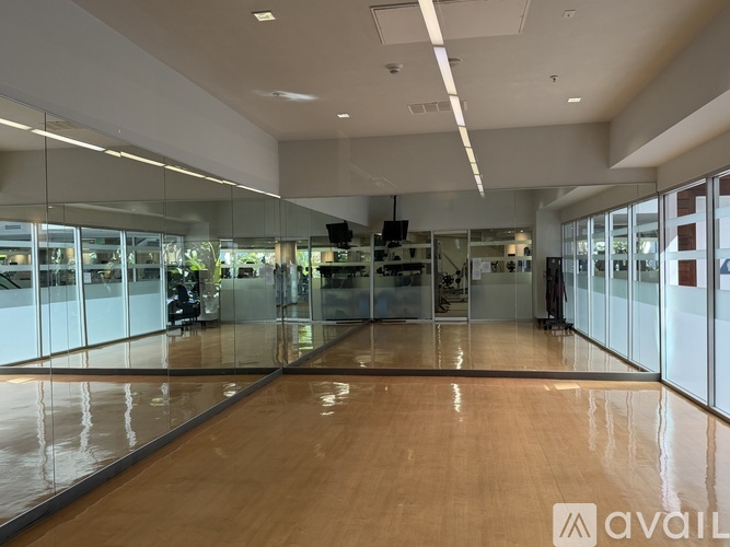 A spacious room with wooden floors and glass walls.