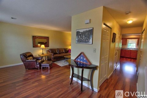 A living room with a couch, chair, and a small table with a flag on it.