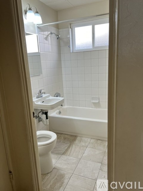 A bathroom with a toilet, sink, and bathtub.