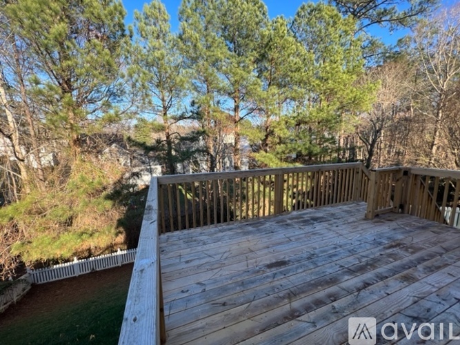 A wooden deck overlooks a grassy area with trees.