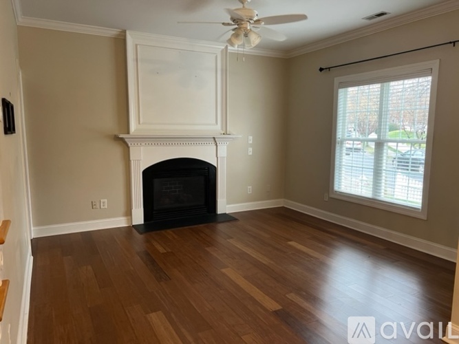 A living room with a fireplace and a ceiling fan.