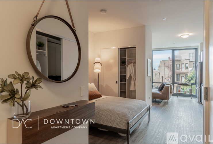 A bedroom with a bed, a mirror, and a lamp.