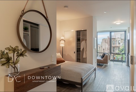 A bedroom with a bed, a mirror, and a lamp.
