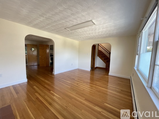 A room with wooden floors and a staircase.
