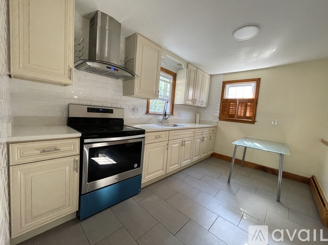 A kitchen with a black oven and white cabinets.