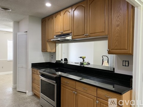 A kitchen with wooden cabinets and black countertops.